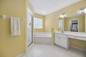 The ensuite bath is spacious in scale, with large vanity ...