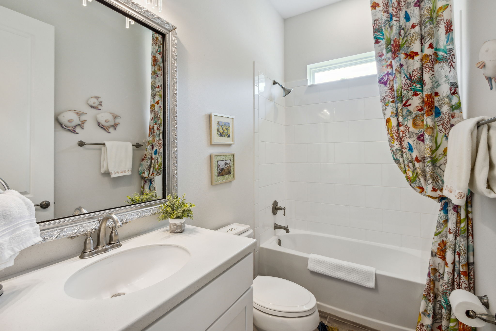 The guest bath with tiled surround and sophisticated accents