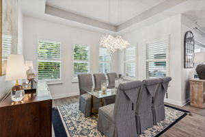 Roomy dining area with a chic chandelier and plenty of space for larger tables ...