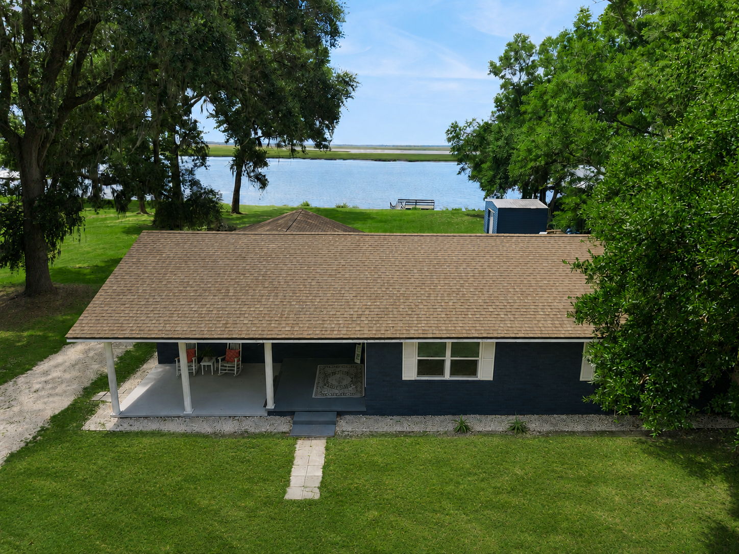 ...while the home sits comfortably between the road and the river, surrounded by mature trees and open lawn.