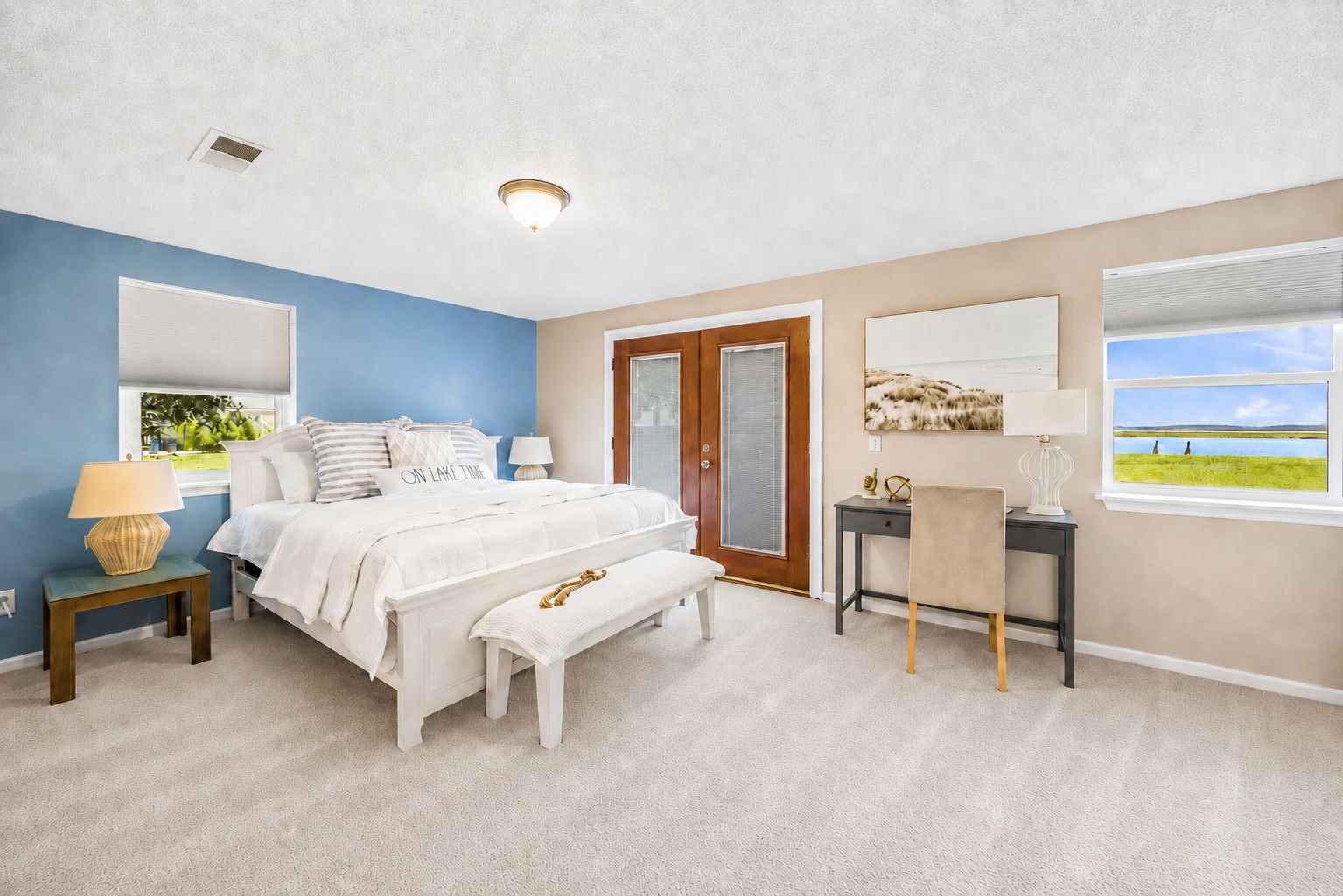 The spacious primary suite enjoys water views and direct access to the outdoors...