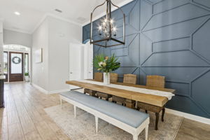 The dining area is subtly recessed, defining the space while maintaining an open flow...