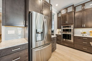 ... beautifully paired with crisp Carrara quartz countertops and a coastal blue backsplash