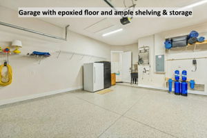 The garage features an epoxy-coated floor, utility sink, and additional shelving and cabinet storage