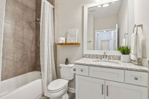 The guest bath is upgraded as well, with granite vanity, framed mirror and tiled shower/tub combo