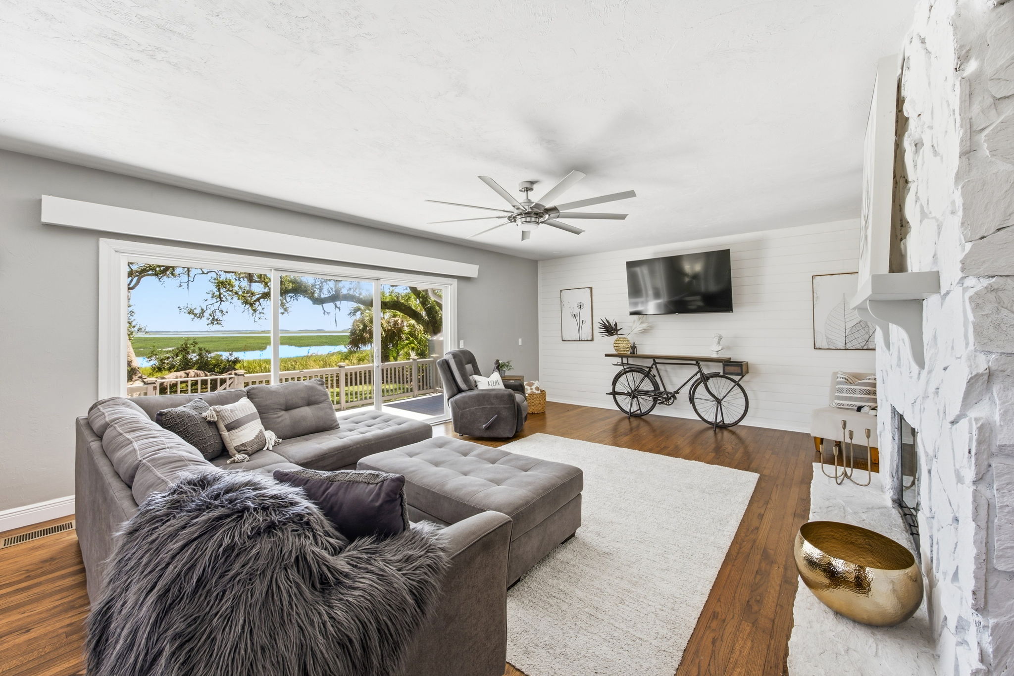 … opening to a generous living room where broad glass doors frame the marsh and water beyond