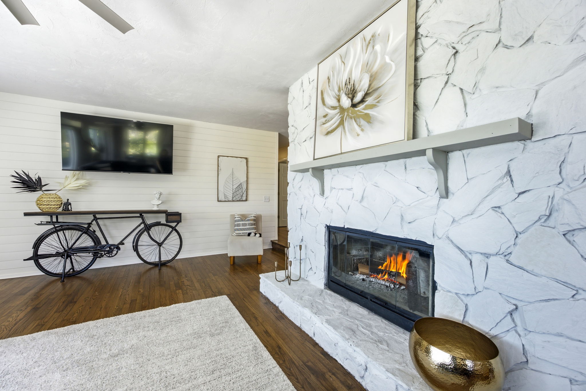 A painted stone fireplace anchors the room, adding texture, character and an inviting place to gather