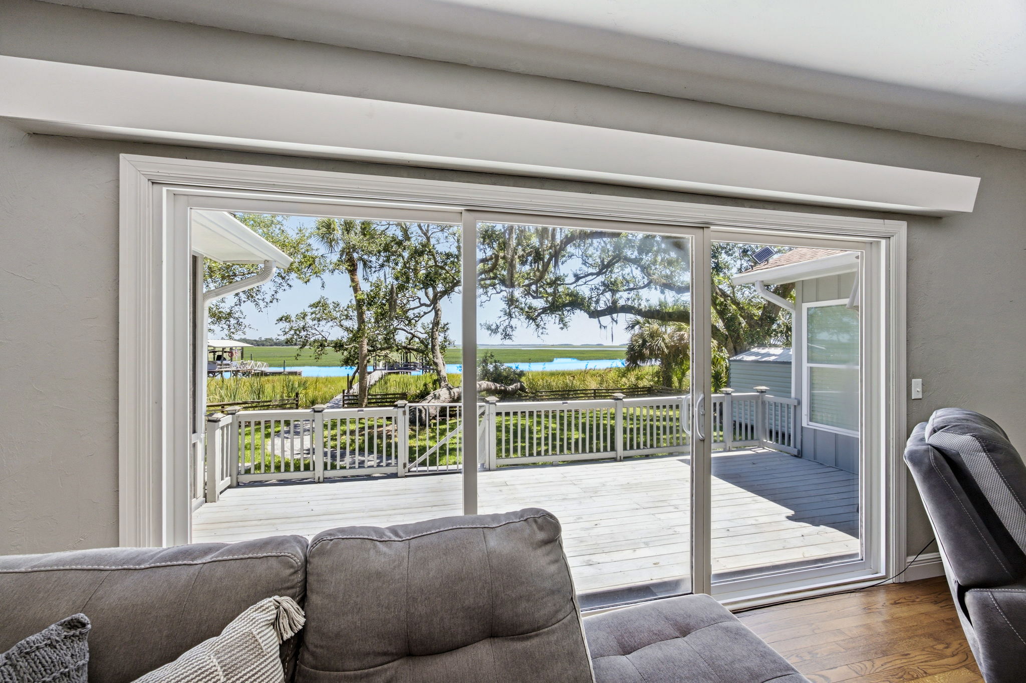 Just beyond the glass, the rebuilt deck extends daily living toward the marsh, water and private dock