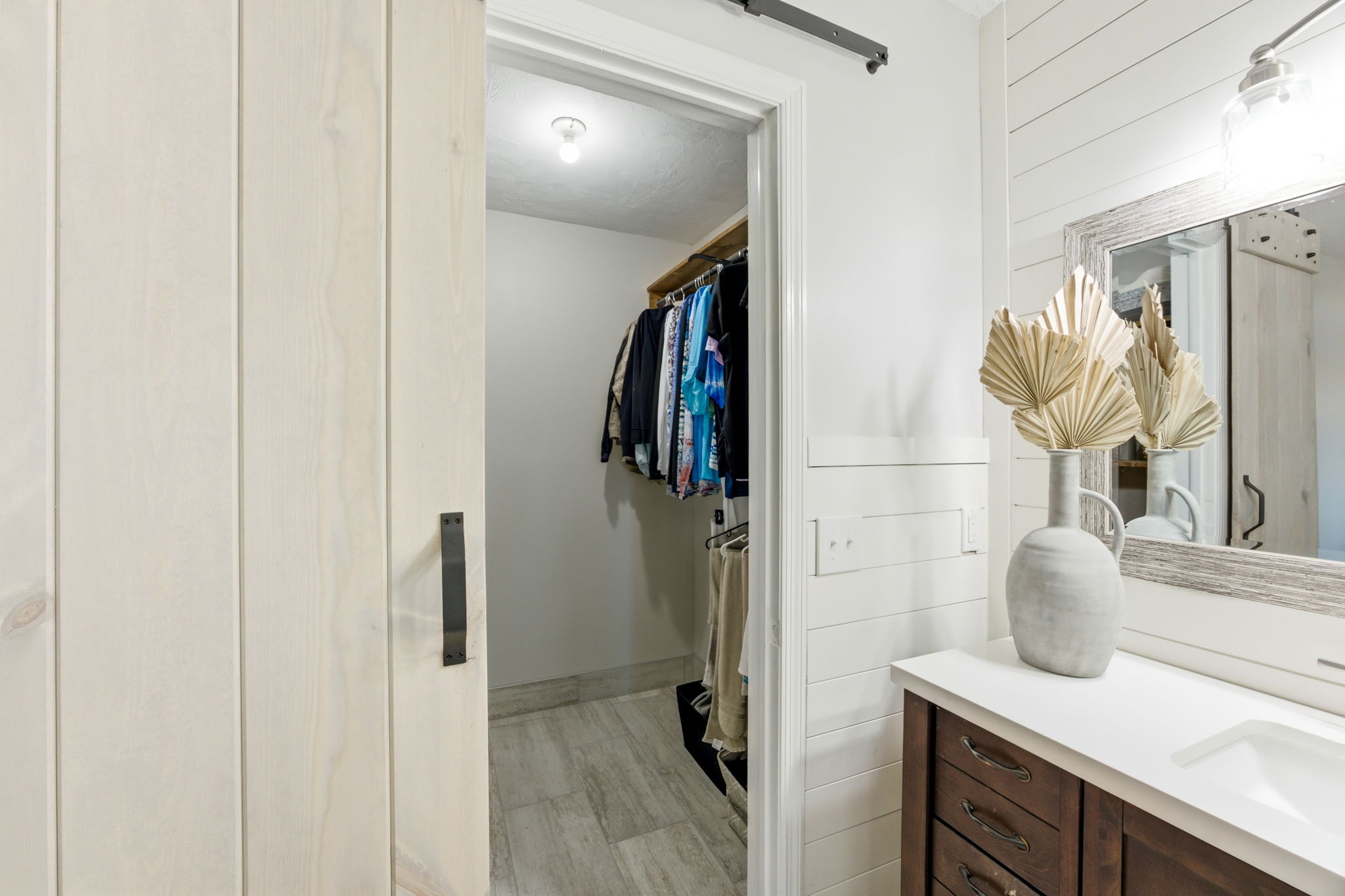 A private walk-in closet sits just off the vanity, keeping storage close while preserving the room’s clean lines