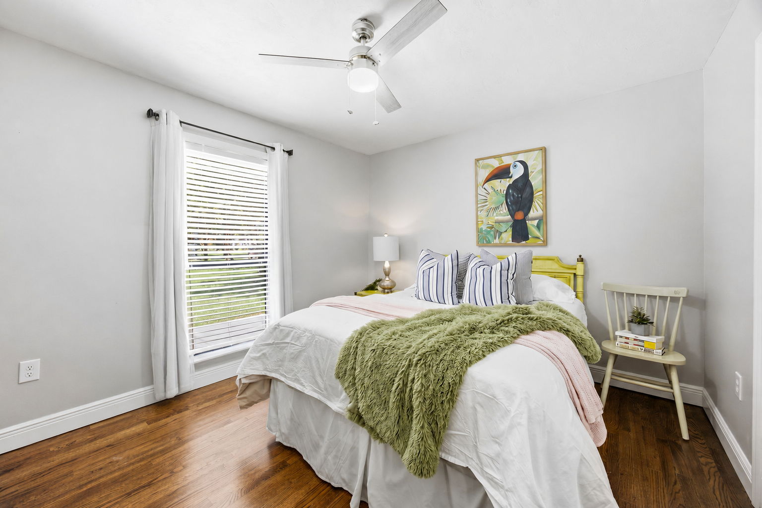 The first guest bedroom continues the home’s oak flooring and offers a comfortable retreat with soft natural light