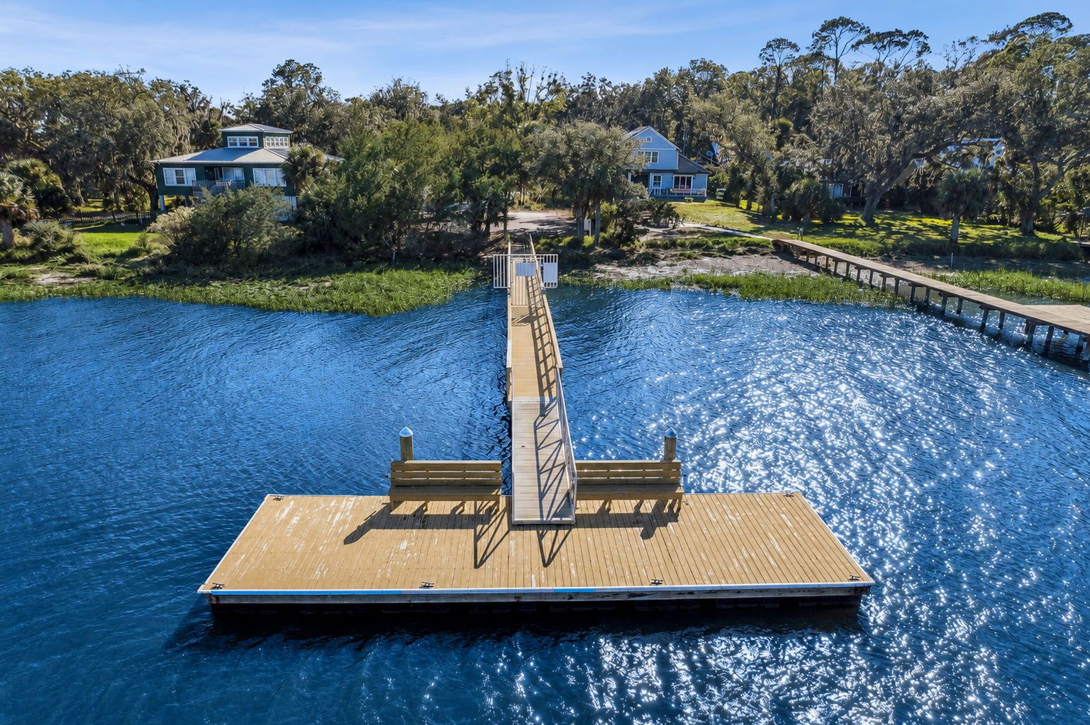 A floating platform extends the pier into open water, offering space to pause and take in the setting