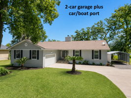 Thoughtful function complements the setting, with a two-car garage and covered space for a boat or additional vehicle
