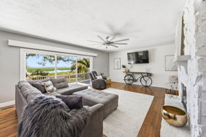 … opening to a generous living room where broad glass doors frame the marsh and water beyond