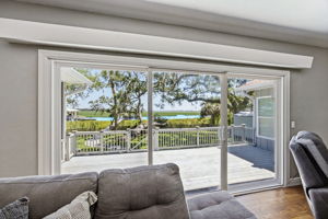 Just beyond the glass, the rebuilt deck extends daily living toward the marsh, water and private dock