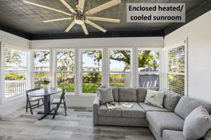 Just off the primary suite, a private heated and cooled sunroom creates a quiet retreat beside the water