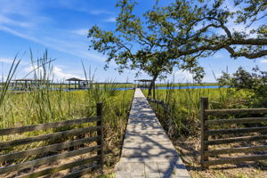 A private walkway leads through the marsh, drawing you from the backyard directly toward the dock