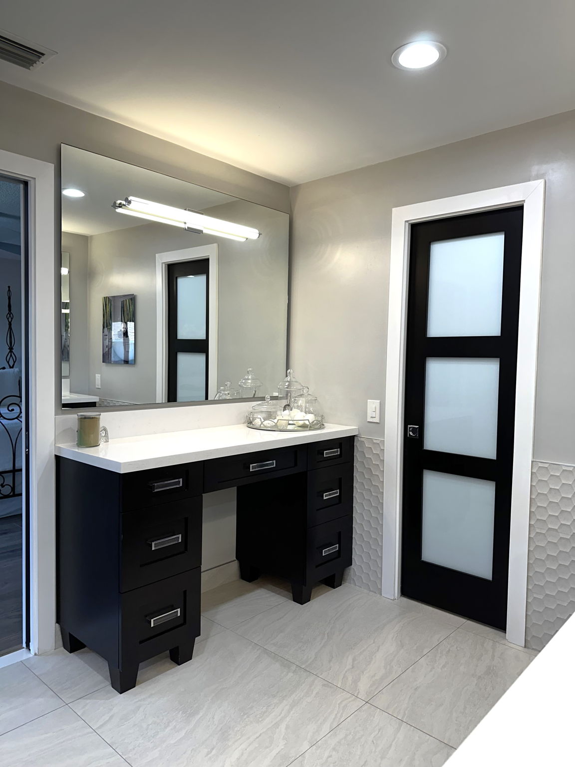 Make up vanity and opaque glass door leading to the private toilet