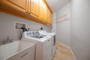 Laundry room with lots of cabinet storage and clothes hanging space plus floor space for 3 laundry baskets back in the corner.  And a storage room off to the right.