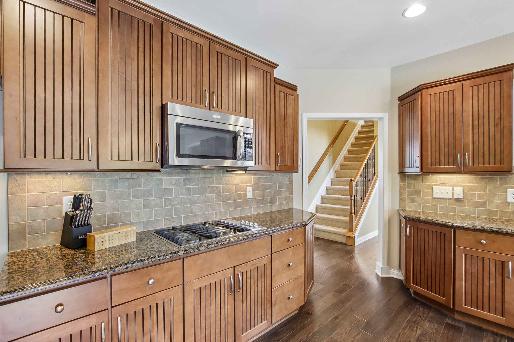 Kitchen offers tons of cabinet and counter space with tiled backsplash and under cabinet lighting