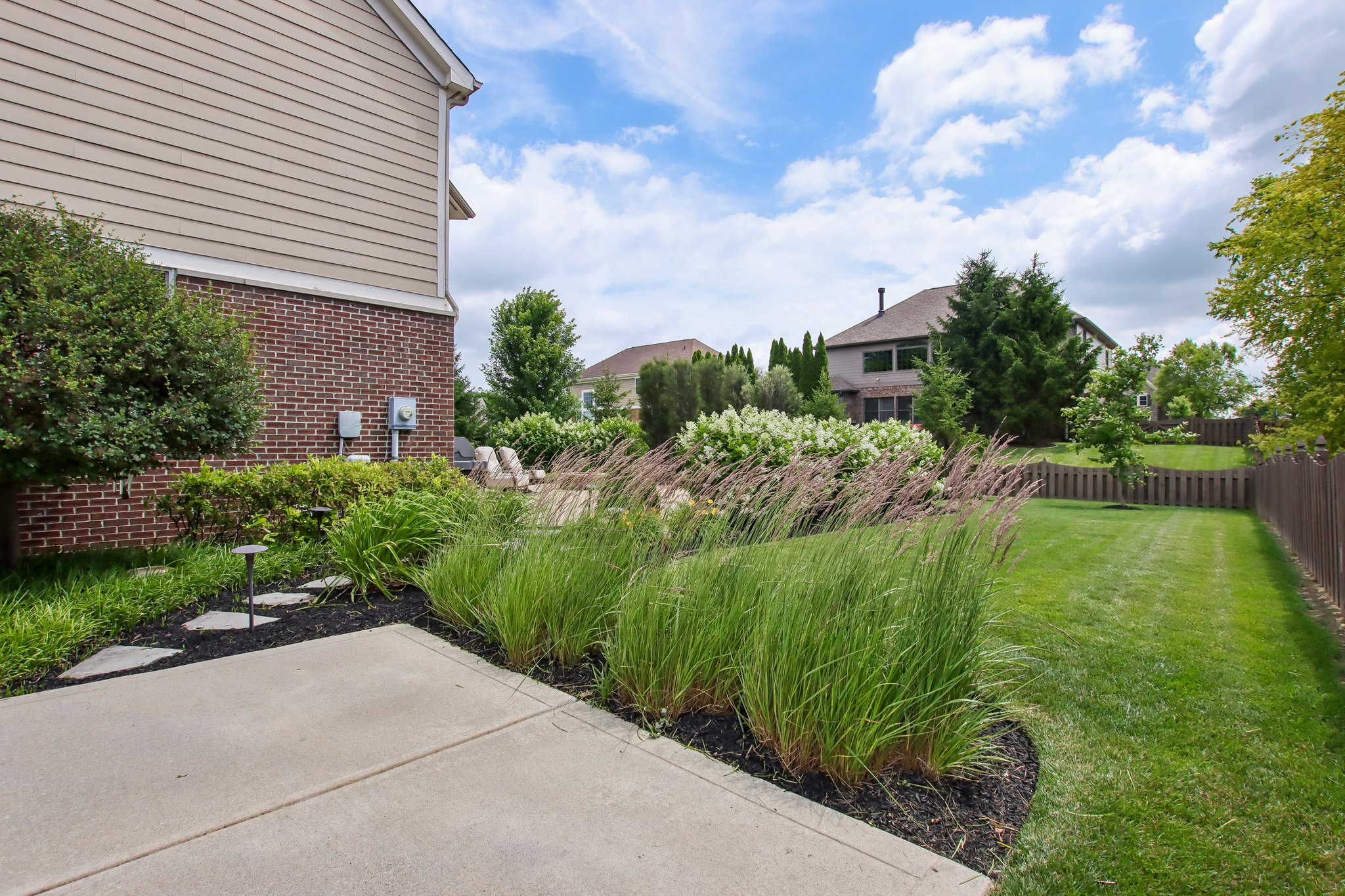 View of the backyard from the extended driveway with flagstone walk path