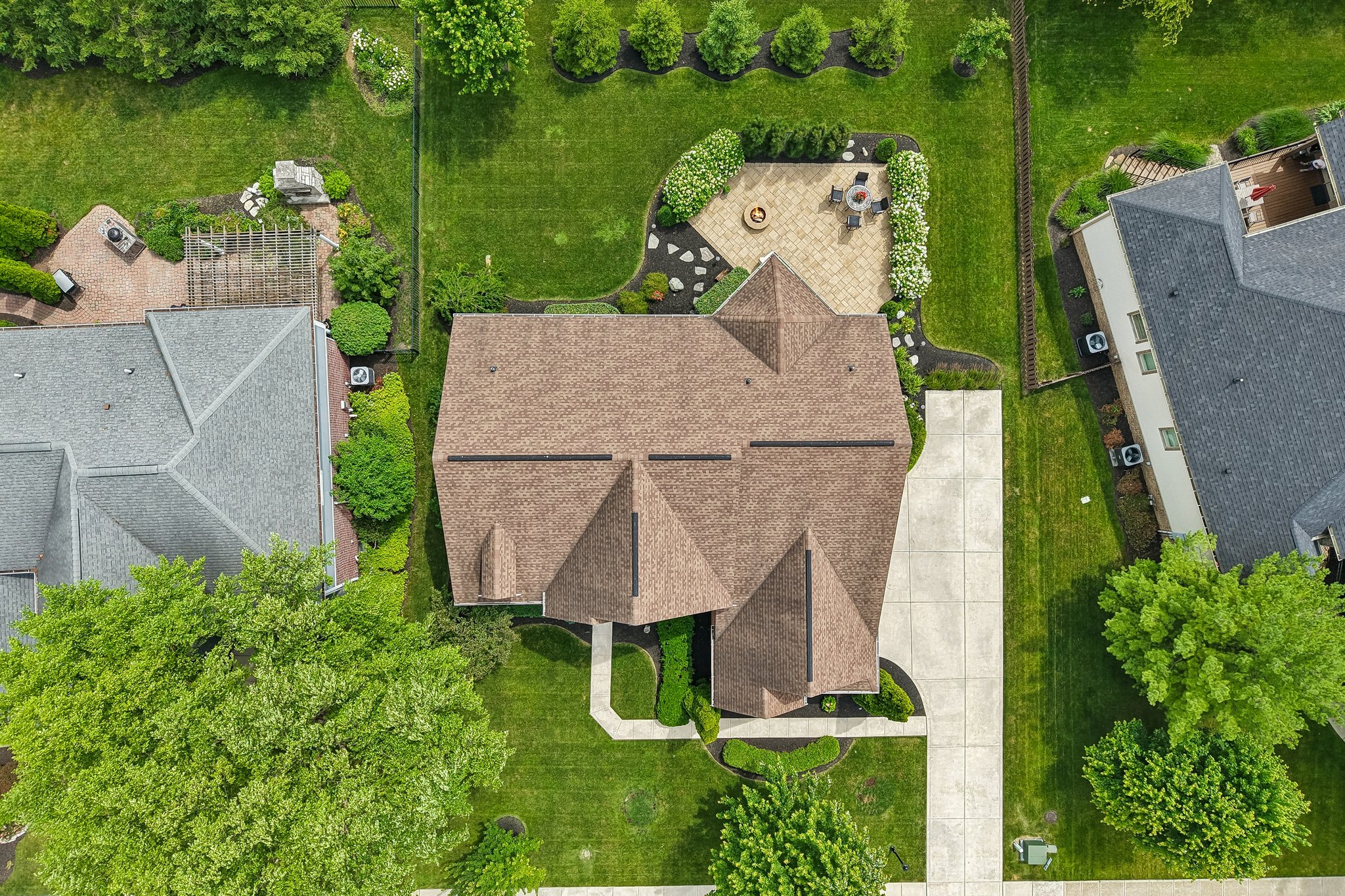 Aerial view directly overhead with tall evergreens and other plantings creating a private backyard