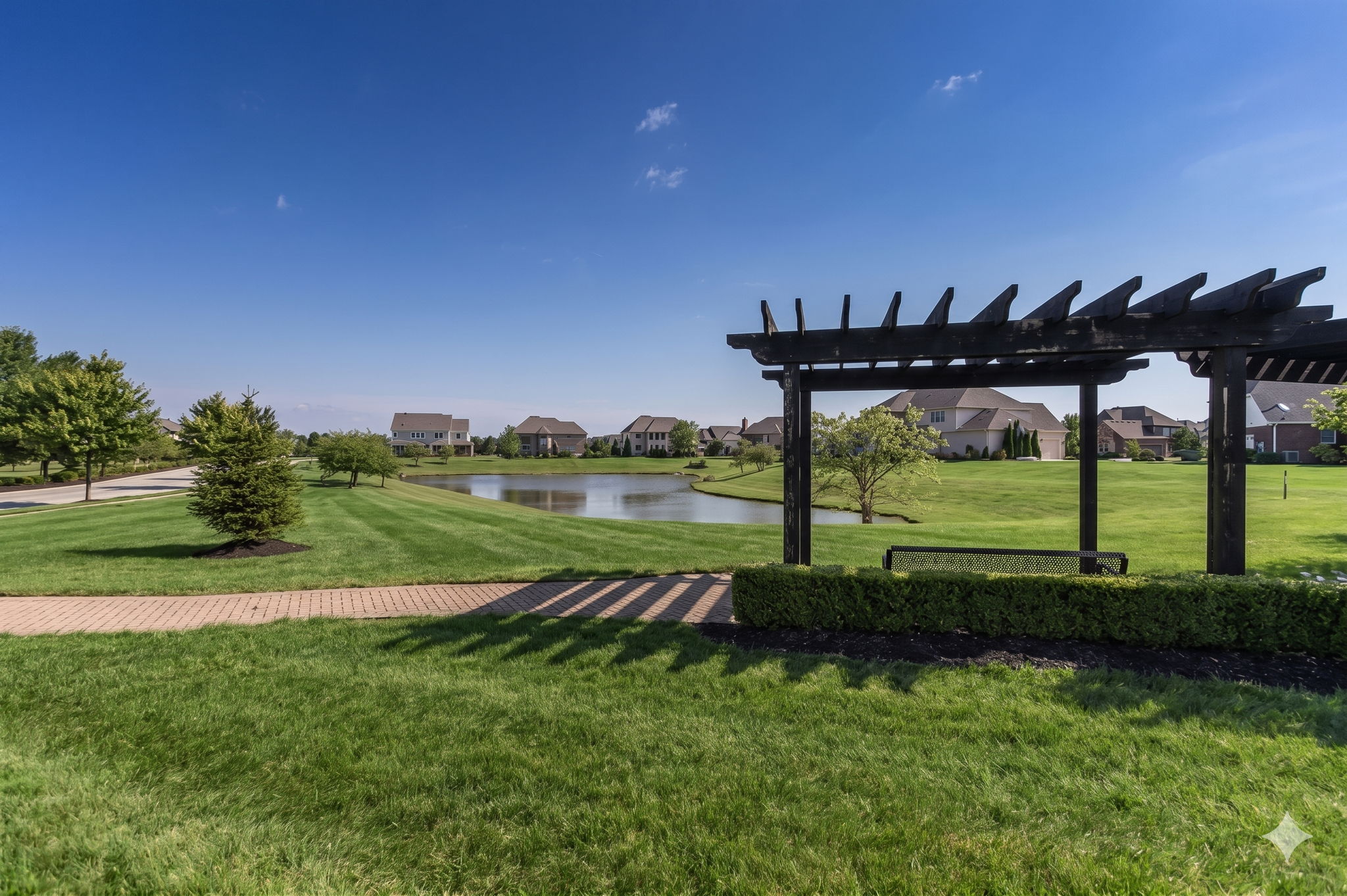 Enjoy the serene setting under the community pergola with pond view