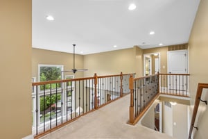 Upstairs walkway with iron spindles overlooks the Great Room and Foyer