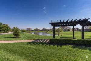 Enjoy the serene setting under the community pergola with pond view