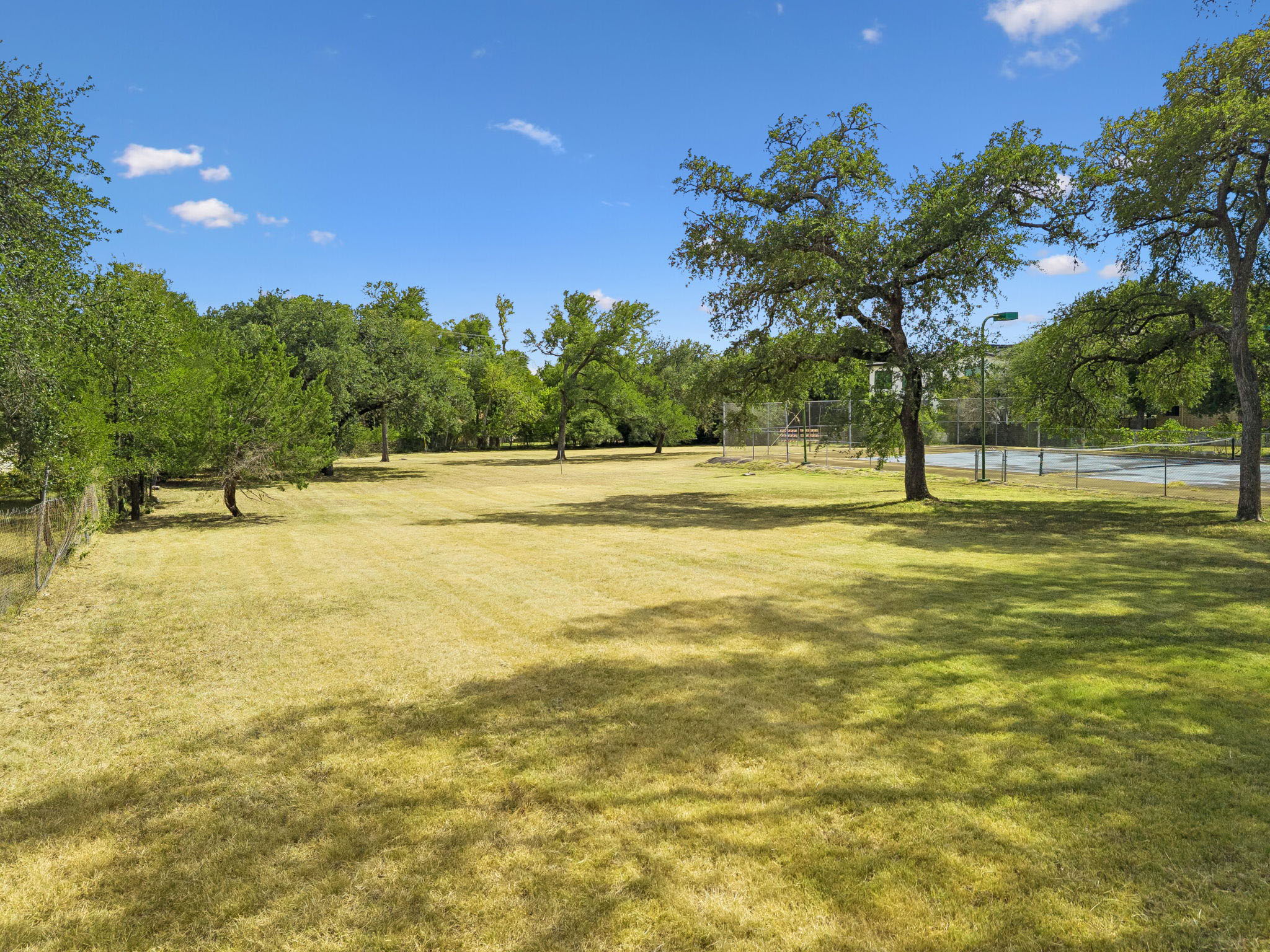 Spanning more than 3 acres within Austin city limits, this expansive estate offers a rare sense of space and privacy, with sweeping lawns and a private fenced tennis court.