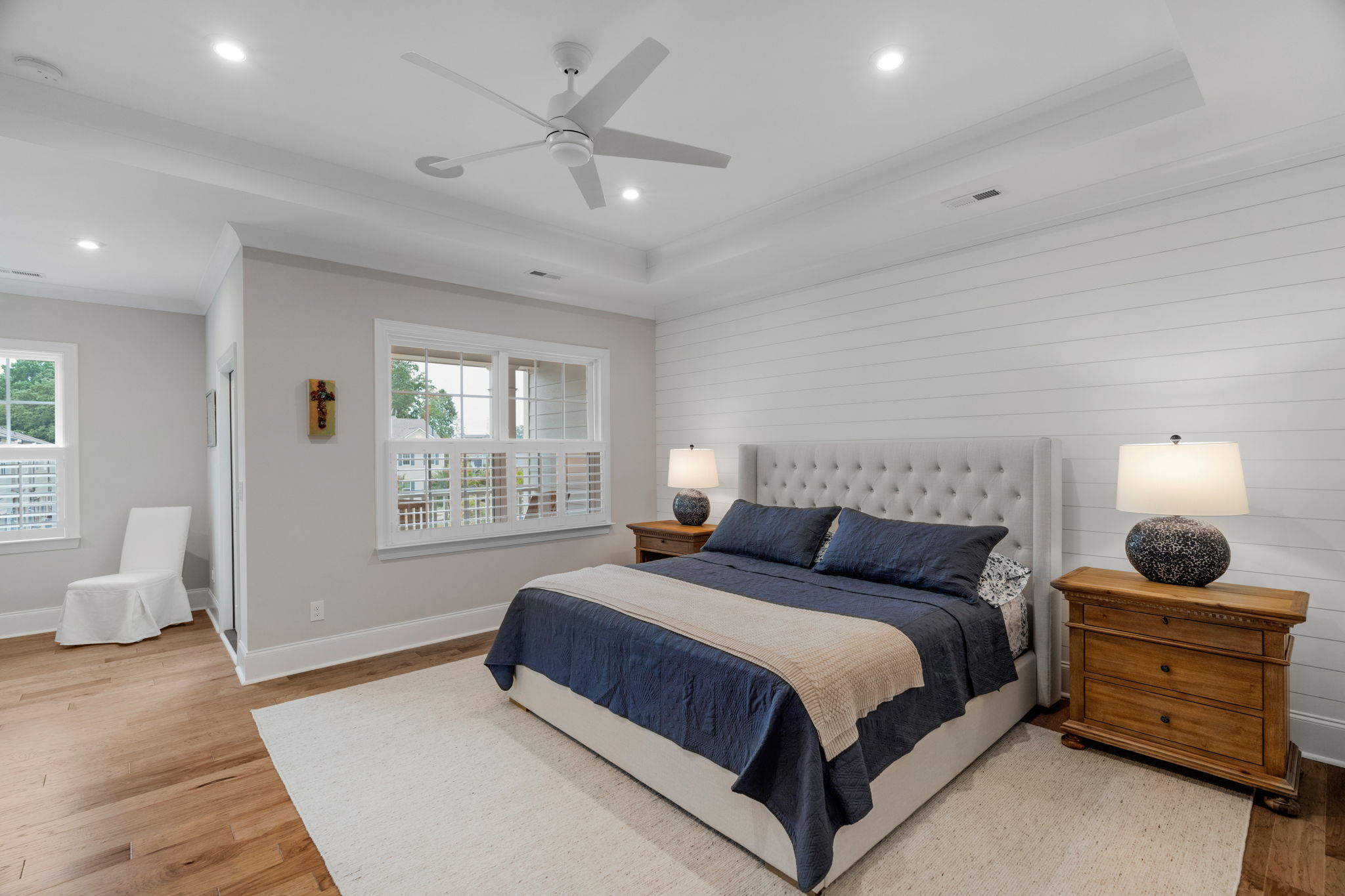 Primary Bedroom with tray ceiling, accent wall, sitting room and private balcony