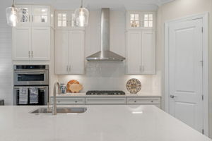 Upgraded Kitchen including up-to-ceiling cabinetry with elegant lighted glass-front upper cabinets